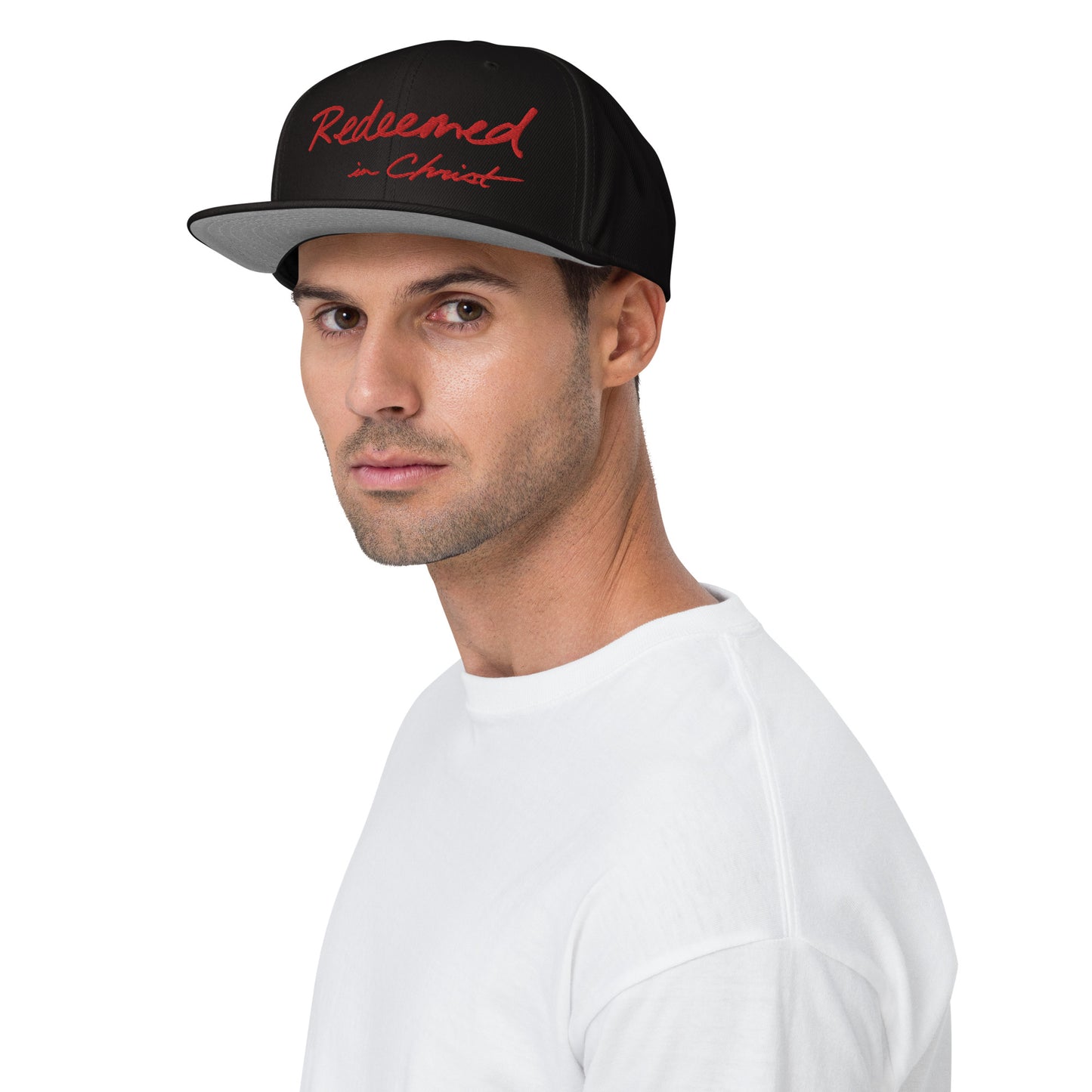 REDEEMED IN CHRIST (red embroidery) — Unisex Snapback Hat