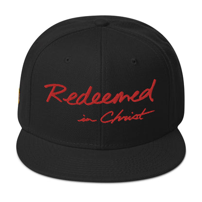 REDEEMED IN CHRIST (red embroidery) — Unisex Snapback Hat