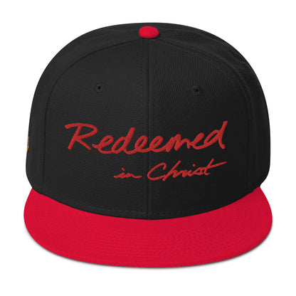 REDEEMED IN CHRIST (red embroidery) — Unisex Snapback Hat