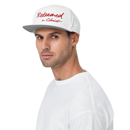 REDEEMED IN CHRIST (red embroidery) — Unisex Snapback Hat